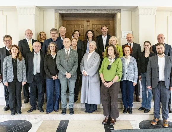 Das Foto zeigt 18 Personen vor einer Holztür. Es wurde anlässlich eines Delegationsbesuchs der Babeș-Bolyai Universität Cluj-Napoca aufgenommen.