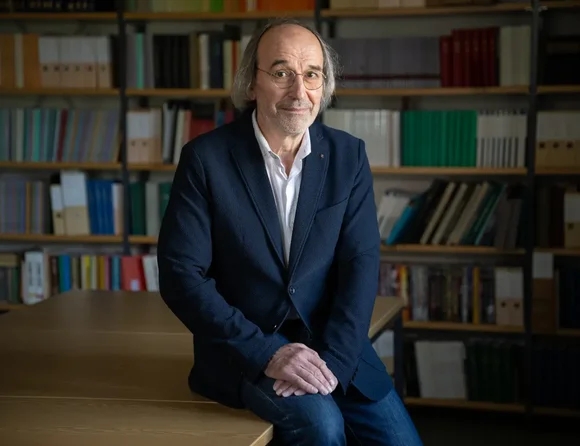 Das Foto zeigt Dr. Mathias Beer vor einem Bücherregal.