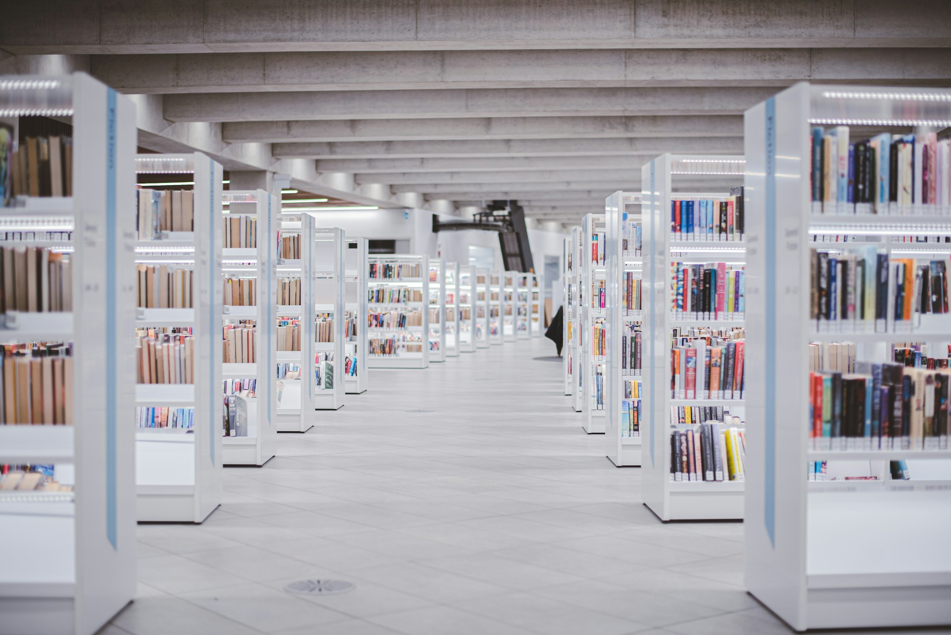 Das Bild zeigt einen Gang mit Bibliotheksregalen.