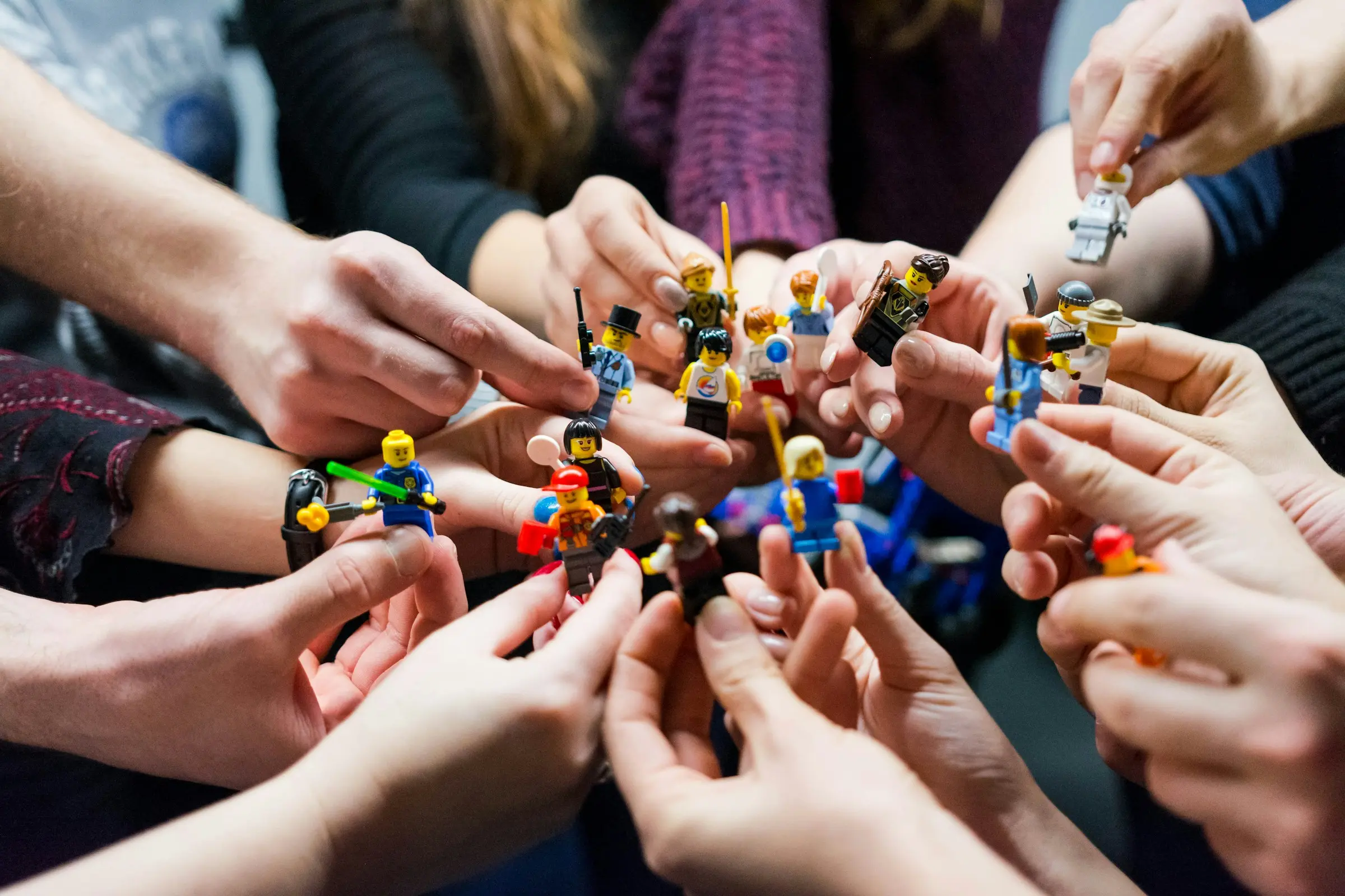 Bild zeigt Hände, die Legofiguren halten.